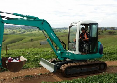 Dial-a-Tow's mini excavator towing agricultural machinery in the hilly terrains of South Australian country