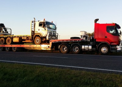 Towing a heavy vehicle across the borders on our low-bed tilt trucks