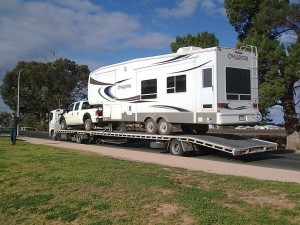 One of our low-bed semi trailers towing a broken down caravan along with the caravan towing vehicle