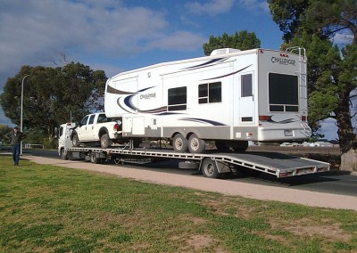One of our low-bed semi trailers towing a broken down caravan along with the caravan towing vehicle