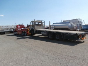 A Mac low loader tilt truck transporting a heavy trailer truck