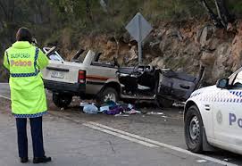 At an accident crash site with the crash car at rest in a horizontal position posing risk to oncoming traffic