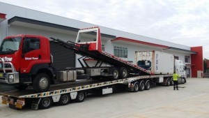 Towing a shipping container with one of our state-of-the-art tilt trucks